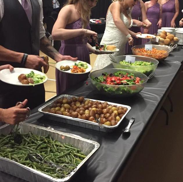 Wedding party going through catering buffet line